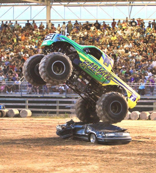 Driver Mac Plecker of Georgia torques his monster truck, "Ballistic," to a flying vertical leap over a single car before a sold-out crowd during the Monster Truck Show at the Emmet-Charlevoix County Fair in Petoskey.