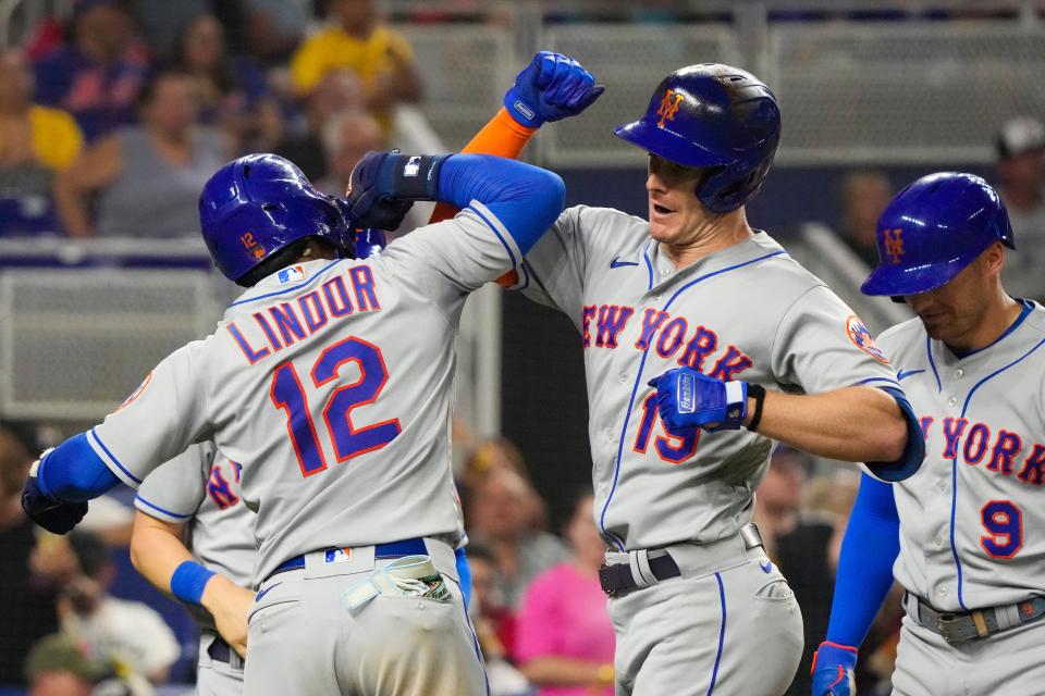 Francisco Lindor and Mark Canha celebrate Canha's grand slam against the Marlins on Saturday.