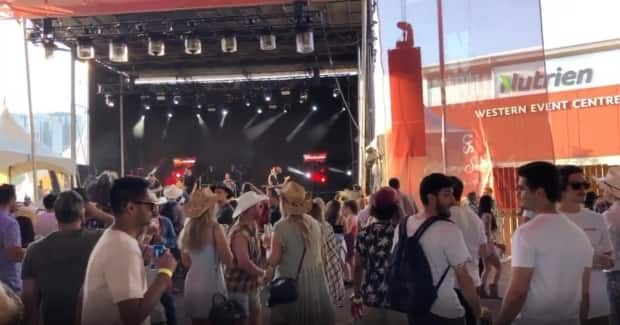 Partygoers crowd near the stage at Nashville North at the Calgary Stampede on July 10, 2021. The Stampede requires either proof of vaccination or a negative rapid COVID-19 test to enter the venue.  (Calgary Stampede/Twitter - image credit)