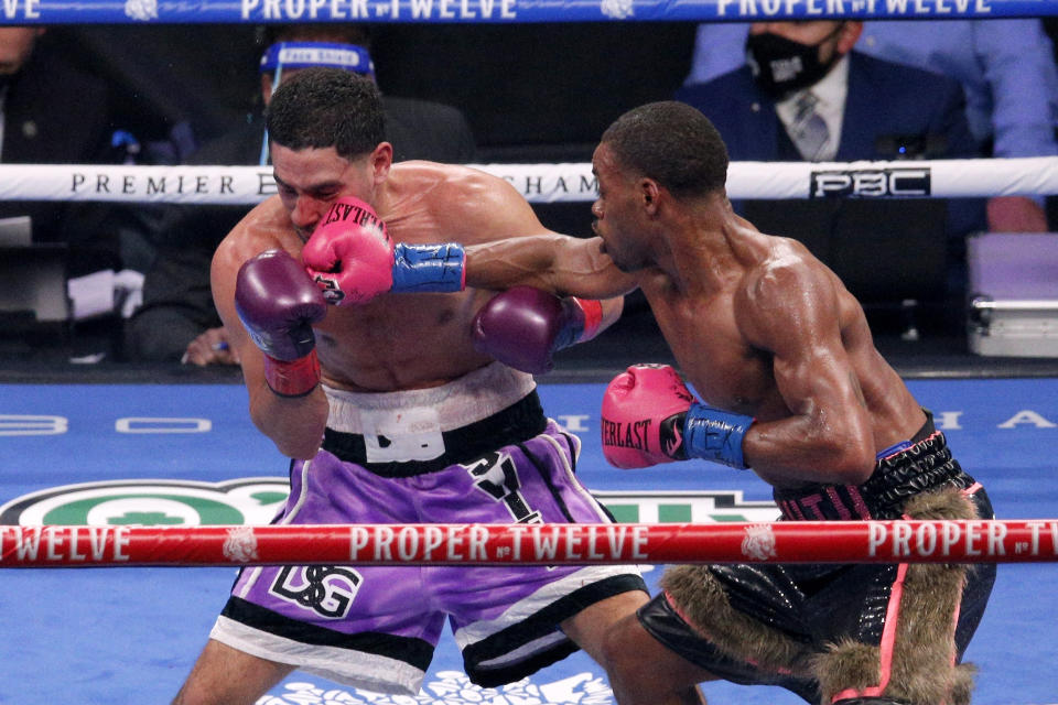 Danny Garcia, left, is hit by Errol Spence Jr. during the WBC IBF welterweight championship boxing bout in Arlington, Texas, Saturday, Dec. 5, 2020. (AP Photo/Brandon Wade)