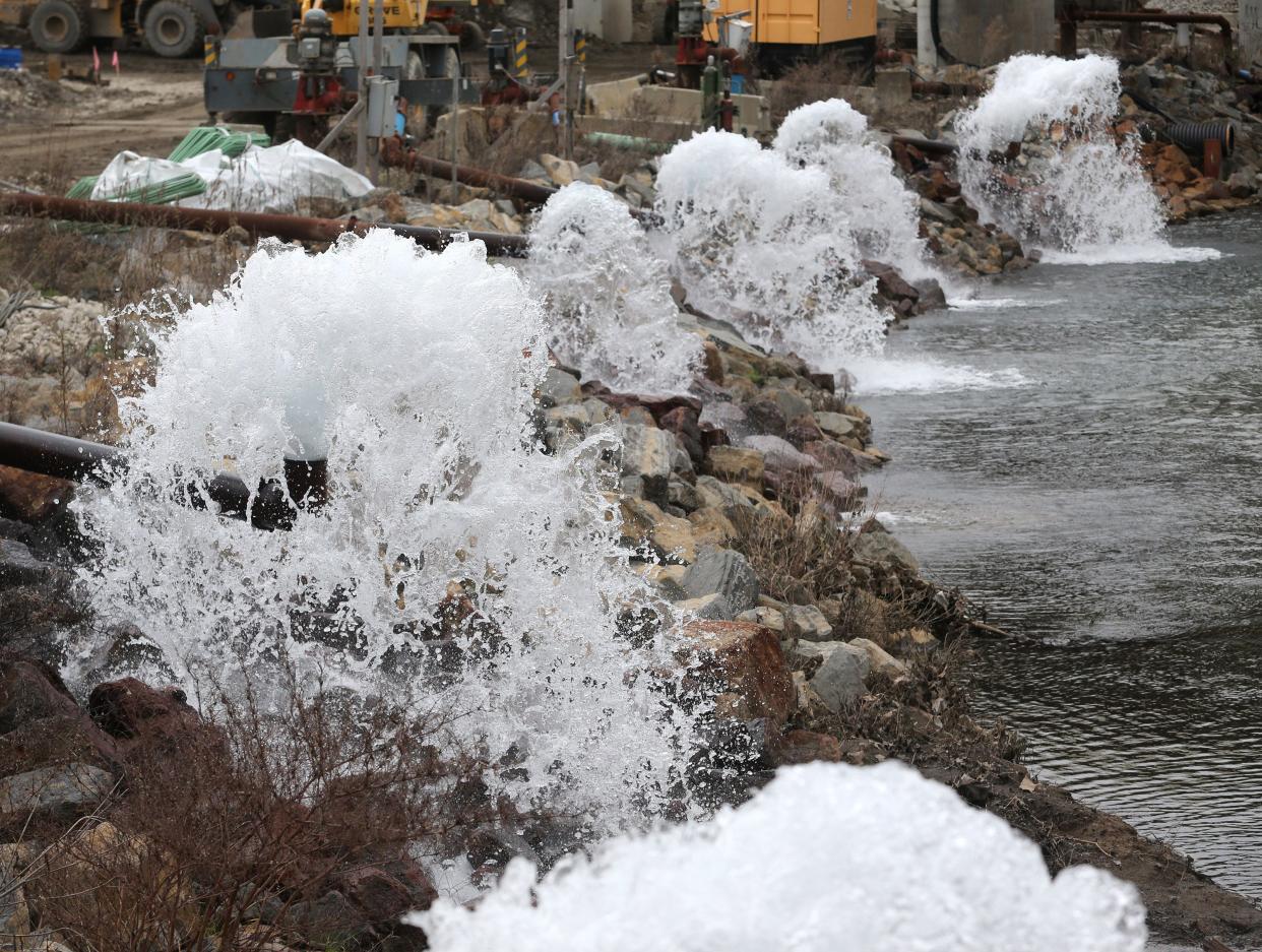 Water pours from large pipes into the West Branch Nimishillen Creek near construction on the U.S. Route 30 and Interstate 77 interchange in Canton.