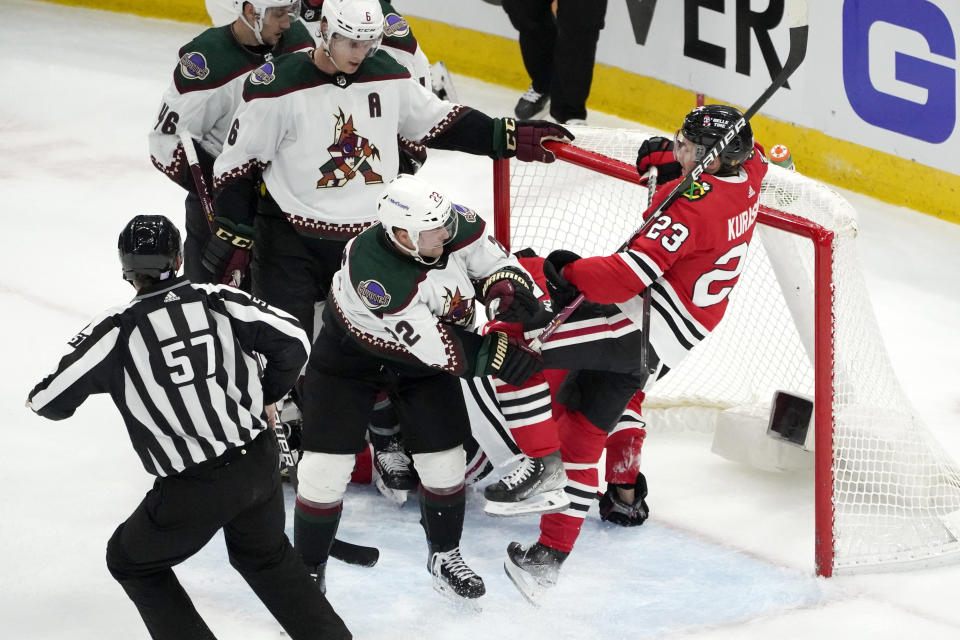 Arizona Coyotes' Johan Larsson (22) knocks Chicago Blackhawks' Philipp Kurashev (23) off his skates as small skirmishes break out between the two teams during the second period of an NHL hockey game Friday, Nov. 12, 2021, in Chicago. (AP Photo/Charles Rex Arbogast)