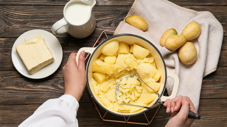 mashing potatoes in a pot