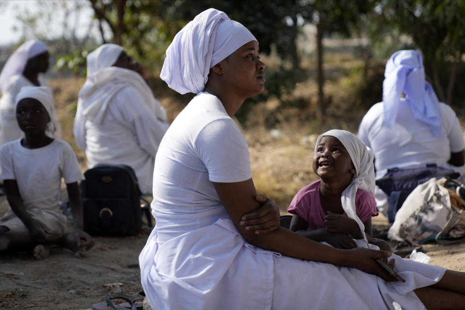 A woman member of the Apostolic church attends a prayer session in a bushy area in the impoverished Epworth region outside Harare, Friday, Sept. 16, 2022. Church members in Zimbabwe are getting their children vaccinated against measles in secret amid a deadly outbreak. It's to avoid being shunned by religious leaders who are opposed to modern medicine. (AP Photo/Tsvangirayi Mukwazhi)