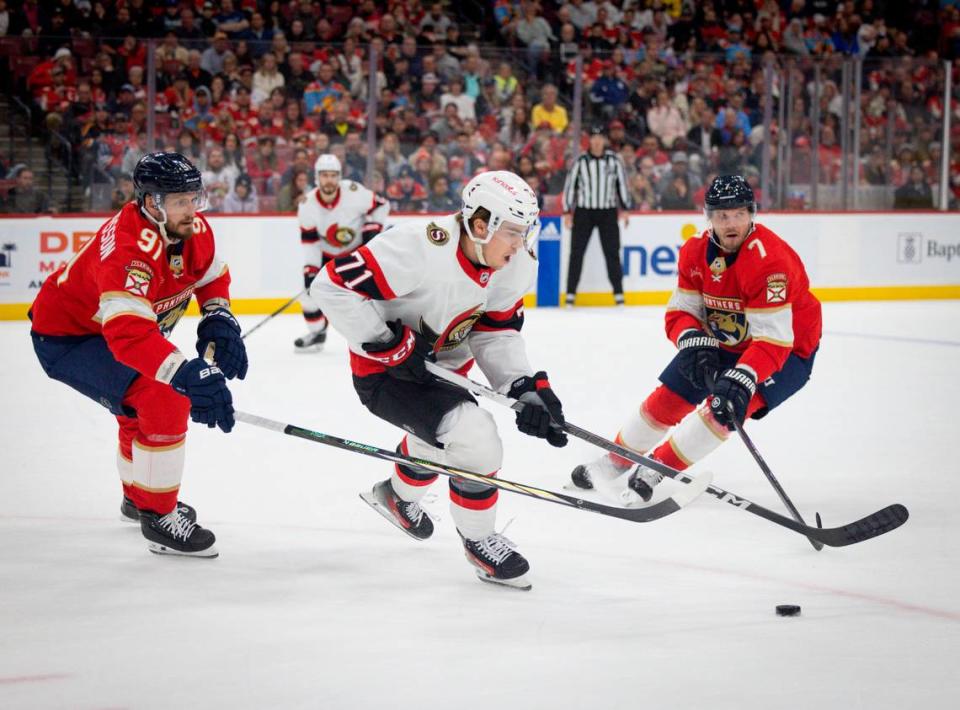 Florida Panthers defensemen Oliver Ekman-Larsson (91) and Dmitry Kulikov (7) try to get the puck from Ottawa Senators center Ridly Greig (71) during the first period of a game on Tuesday, Feb. 20, 2024, at Amerant Bank Arena in Sunrise, Fla.