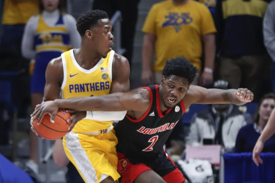 Louisville's Darius Perry (2) reaches for the ball held by Pittsburgh's Xavier Johnson during the first half of an NCAA college basketball game Tuesday, Jan. 14, 2020, in Pittsburgh. (AP Photo/Keith Srakocic)