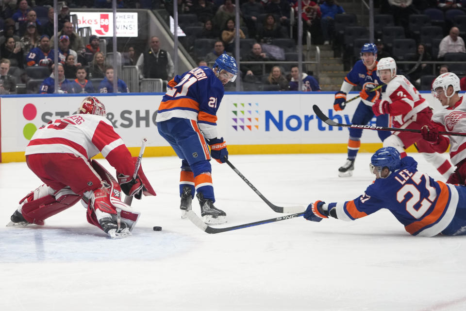 New York Islanders' Anders Lee (27) shoots the puck past Detroit Red Wings goaltender Magnus Hellberg (45) for a goal as teammate Kyle Palmieri (21) watches during the second period of an NHL hockey game Friday, Jan. 27, 2023, in Elmont, N.Y. (AP Photo/Frank Franklin II)