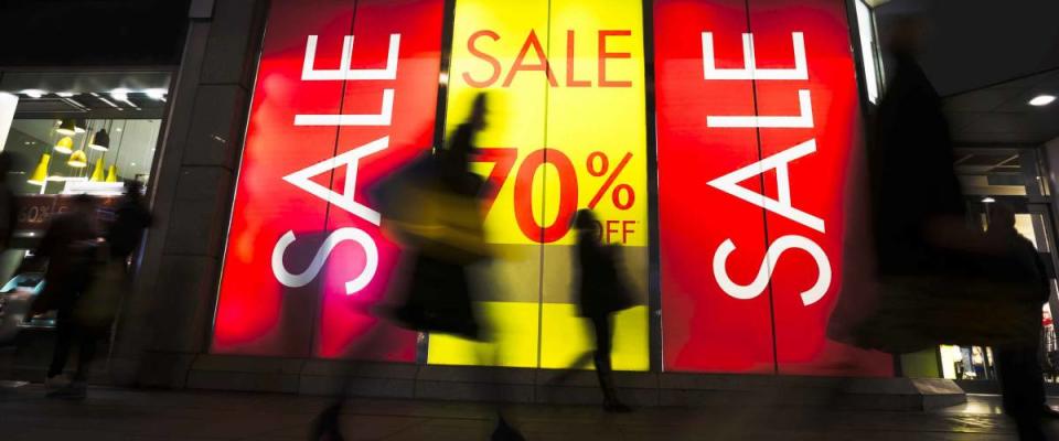 Sale signs in shop window, include silhouette of shoppers