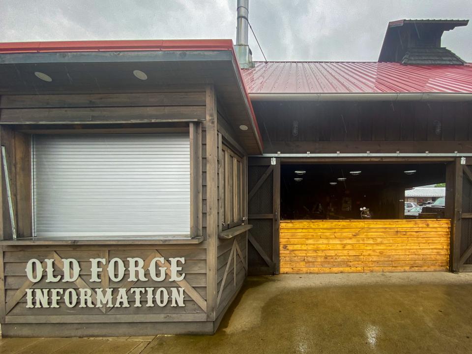 An old wood building with a red roof says "Old Forge Information" on the bottom left side of the building's facade.