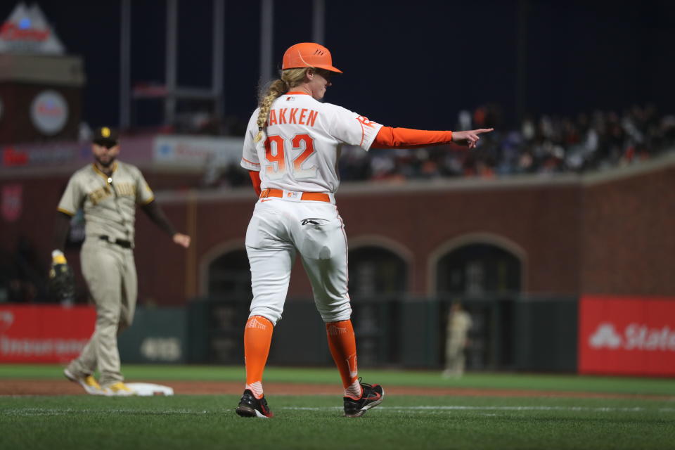 La coach de primera base de los San Francisco Giants Alyssa Nakken va rumbo a tomar su posición en el juego ante los San Diego Padres en el tercer inning del partido en San Francisco, el martes 12 de abril de  2022. (AP Foto/Jed Jacobsohn)