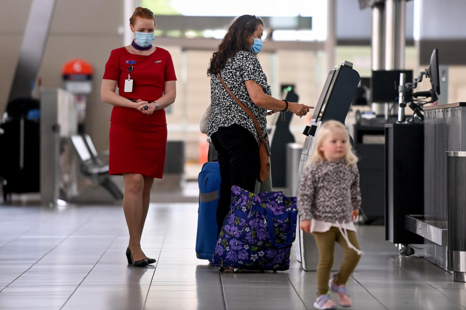 Passengers wear face masks as they check in at the Virgin Australian departures terminal at Sydney Domestic Airport in Sydney, Friday, November 5, 2021.