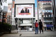<p>Pedestrians look at a screen displaying live news of meeting between North Korean leader Kim Jong Un and US President Donald Trump, in Tokyo on June 12, 2018. (Photo: Martin Bureau/AFP/Getty Images) </p>