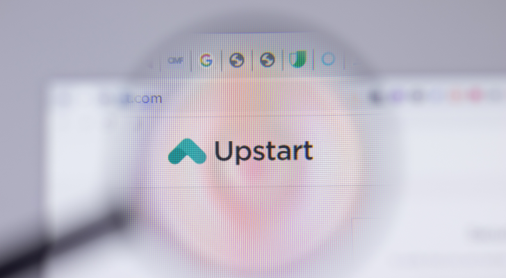 The website for Upstart (UPST) is viewed through a magnifying glass focused on the company's logo.