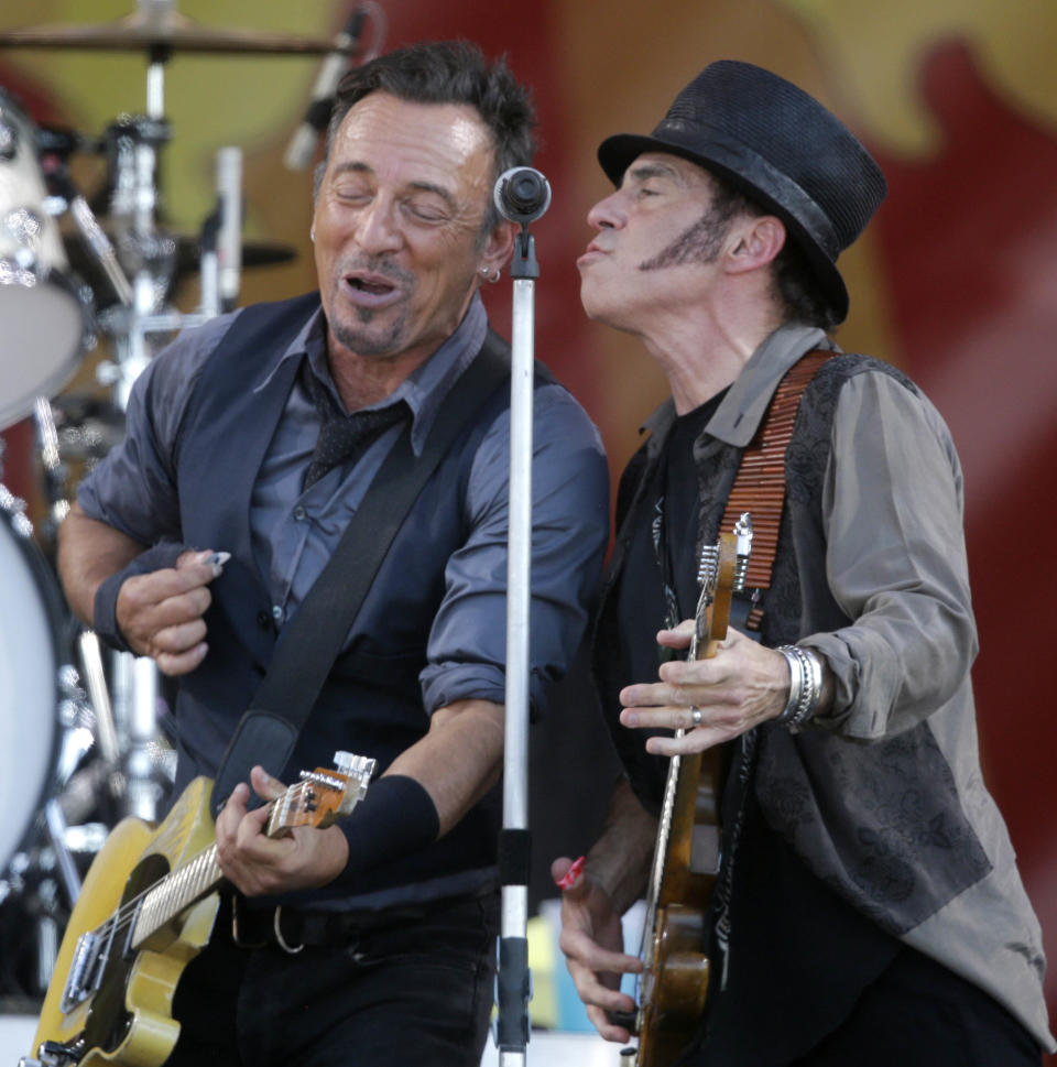 Bruce Springsteen performs at the mike with guitarist Nils Lofgren, right, at the New Orleans Jazz and Heritage Festival in New Orleans, Saturday, May 3, 2014. (AP Photo/Gerald Herbert)