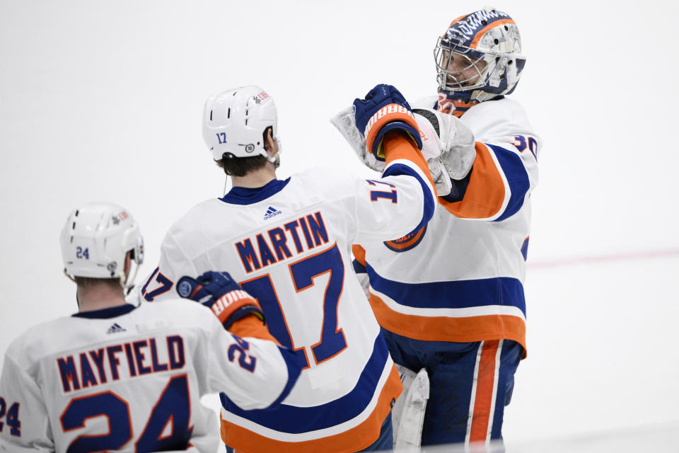 New York Islanders goaltender Ilya Sorokin celebrates with left wing Matt Martin (17) and defenseman Scott Mayfield (24) after an NHL hockey game against the Washington Capitals, Wednesday, March 29, 2023, in Washington. The Islanders won 2-1 in a shootout. (AP Photo/Nick Wass)