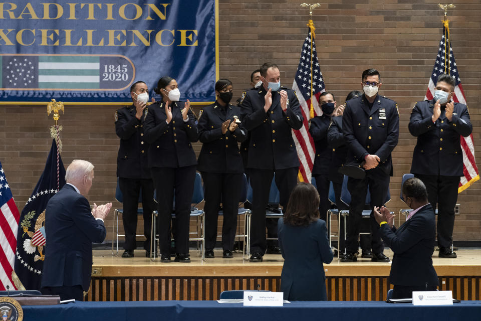 President Joe Biden, left, applauds New York police officer Sumit Sulan, second from top right, during a roundtable to discuss gun violence strategies, at police headquarters, Thursday, Feb. 3, 2022, in New York, along with Gov. Kathy Hochul, D-N.Y., standing lower center, and NYPD Commissioner Keechant Sewel, standing lower right. (AP Photo/Alex Brandon)