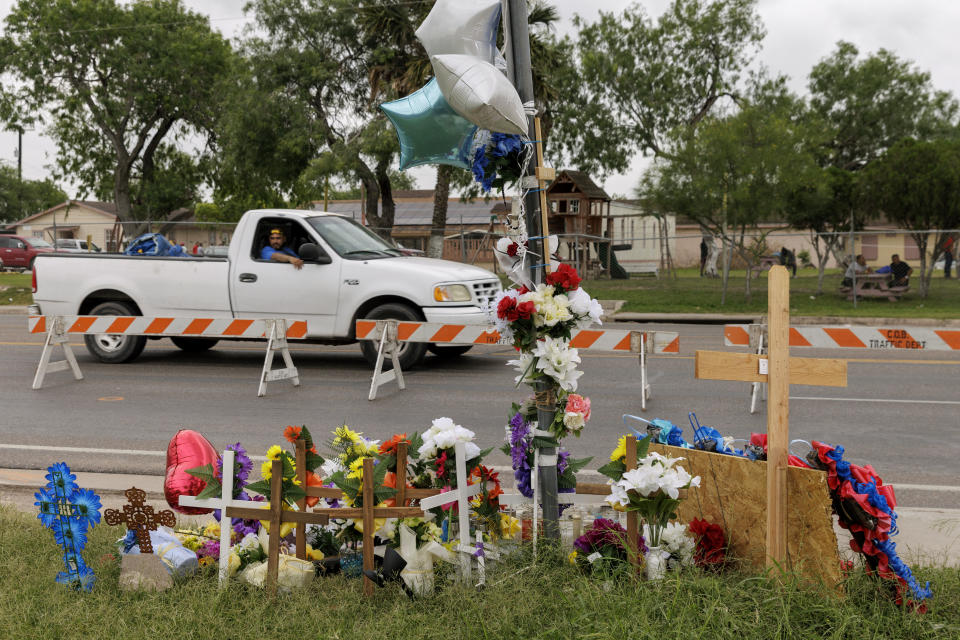 FILE - A passenger looks at a memorial site from a moving vehicle where eight migrants were killed, and several others injured the day before while waiting at a bus stop in Brownsville, Texas, Monday, May 8, 2023. A Texas jury has found George Alvarez guilty of intoxication manslaughter, Friday, June 28, 2024 over the deaths of eight people who were struck by an SUV that plowed into a crowded bus stop outside a migrant shelter on the U.S.-Mexico border. (AP Photo/Michael Gonzalez, File)