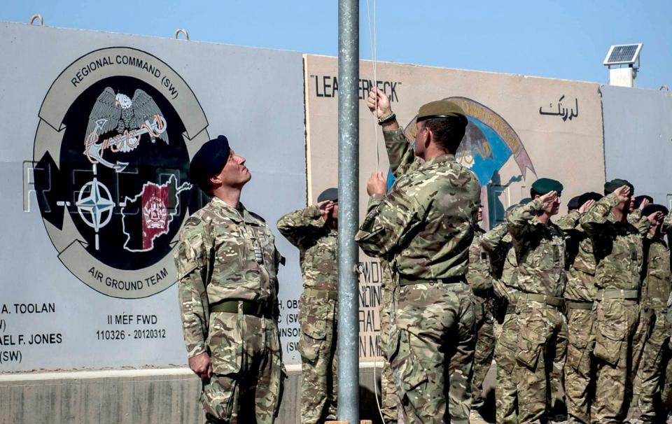 The last Union flag of Great Britain flying above the skies of Helmand Province, Afghanistan, is lowered by Captain Matthew Clark, left, and Warrant Officer 1 John Lilley - Ben Birchall/PA Wire