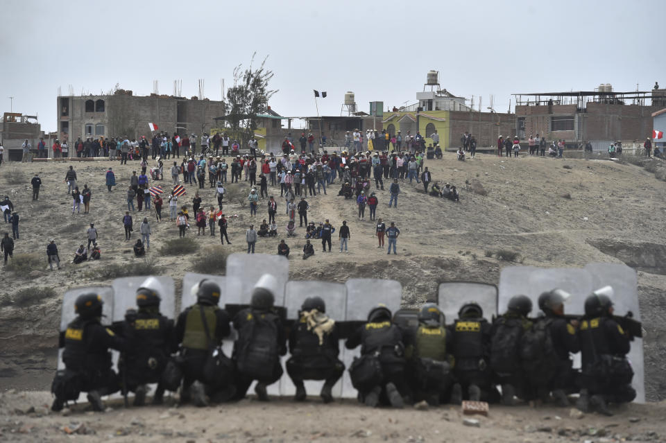 Anti-government protesters face off with security outside Alfredo Rodriguez Ballon airport in Arequipa, Peru, Thursday, Jan. 19, 2023. Protesters are seeking immediate elections, President Dina Boluarte's resignation, the release of ousted President Pedro Castillo and justice for up to 48 protesters killed in clashes with police. (AP Photo/Jose Sotomayor)