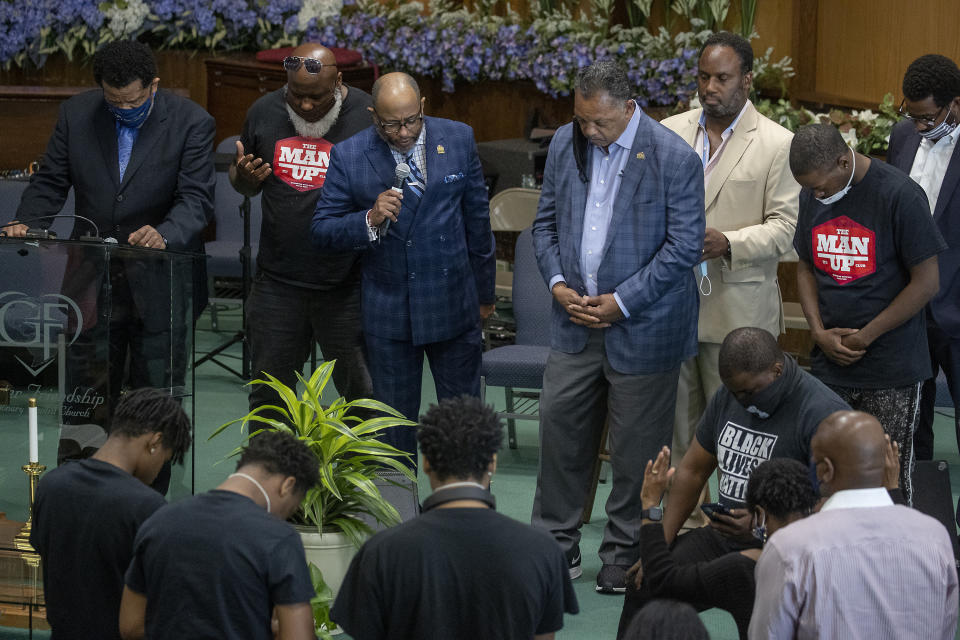 The Rev. Jesse L. Jackson, center right, is surrounded by faith leaders as they stand in prayer after he spoke to send a message of solidarity and demand justice in the death of George Floyd, at Greater Friendship Missionary Baptist Church, Thursday, May 28, 2020 in Minneapolis. (Elizabeth Flores/Star Tribune via AP)