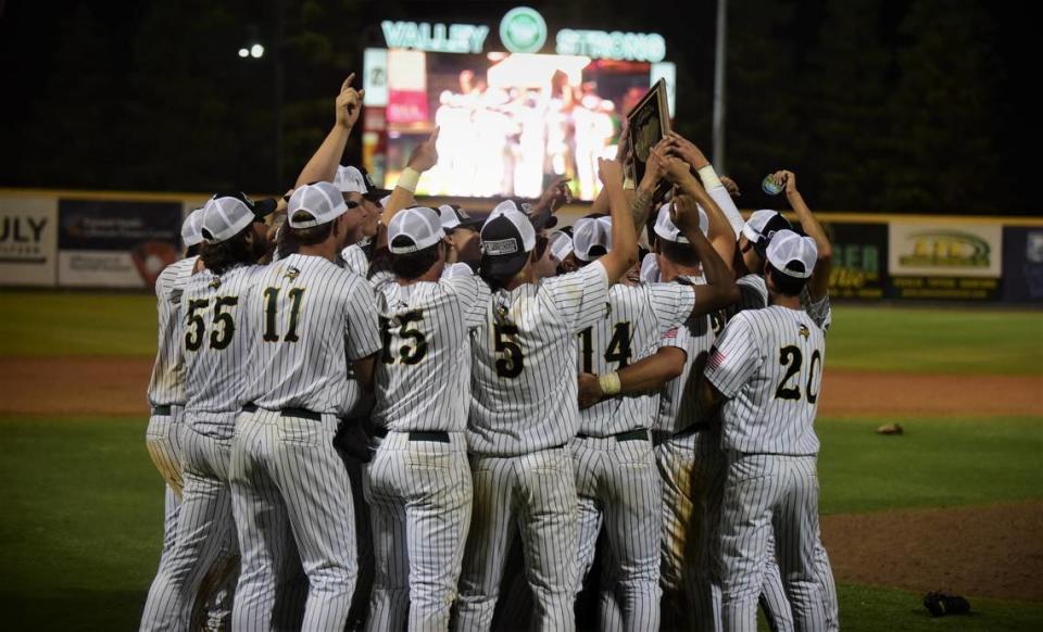 The Kingsburg High School players hoist up the championship plaque after winning the Central Section Division III Valley Championship with a 7-5 victory over Dos Palos on Thursday night at Valley Strong Ballpark in Visalia, Calif.