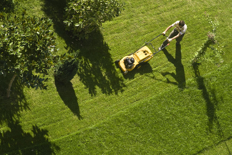 A man is mowing his lawn