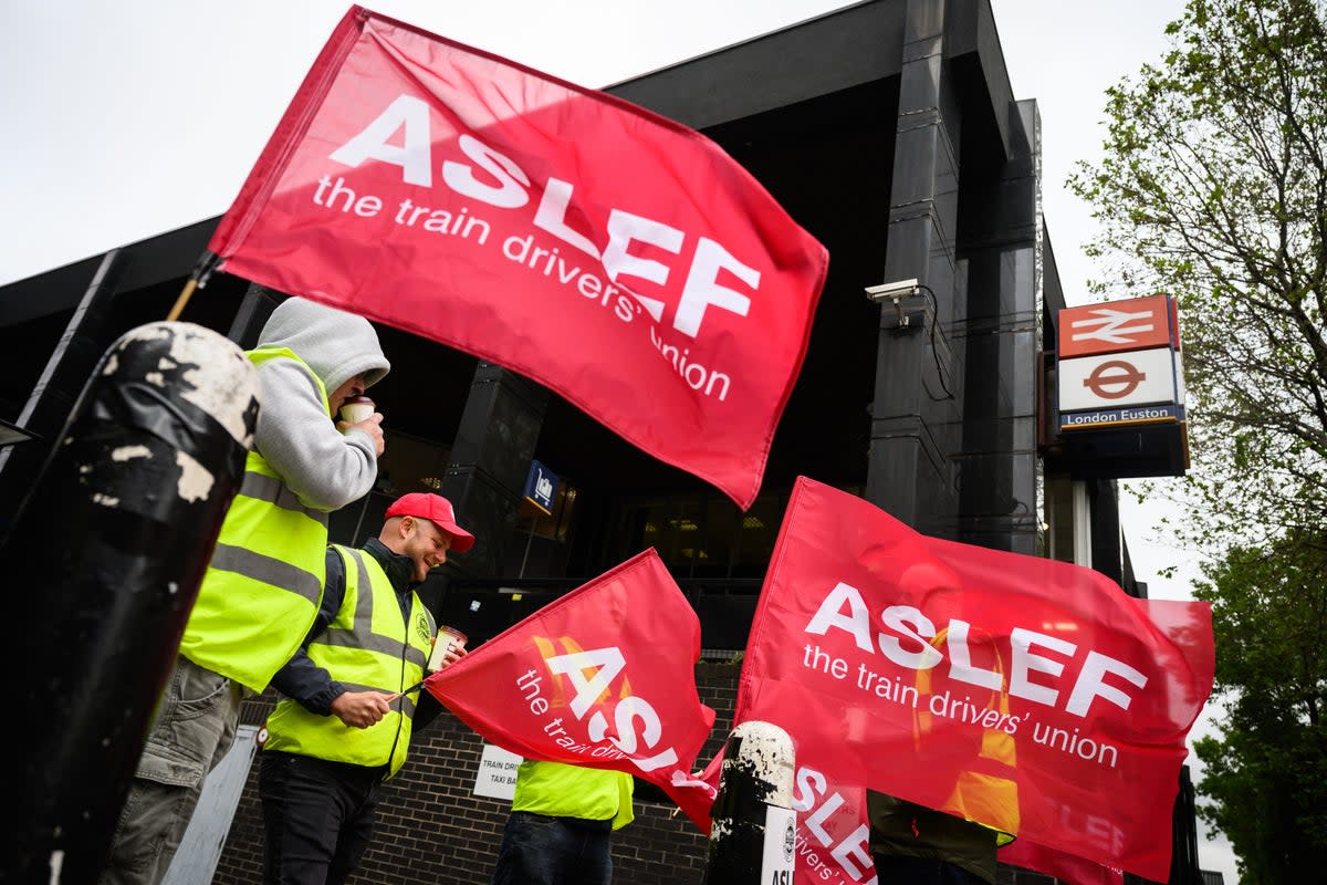 A group of rail workers stand on a picket line outside Euston rail station (Getty Images)