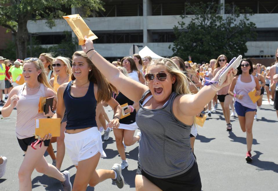 New Delta Zeta sorority members run to their house during Sorority Bid Day outside Bryant-Denny Stadium Sunday, Aug. 18, 2019. The new members gathered in the stadium where they received their bids then ran in groups to the various sorority houses where they were met and greeted by sisters of each house. [Staff Photo/Gary Cosby Jr.]