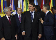 Brazil's President Jair Bolsonaro, center, stands between Uruguay's Presidente Tabare Vazquez, left, and Argentina's President Mauricio Macri during a photo opportunity at the Mercosur Summit in Santa Fe, Argentina, Wednesday, July 17, 2019. The South American trading bloc that includes founding members Brazil, Argentina, Paraguay, and Uruguay, is one of the world's largest. (AP Photo/Gustavo Garello)