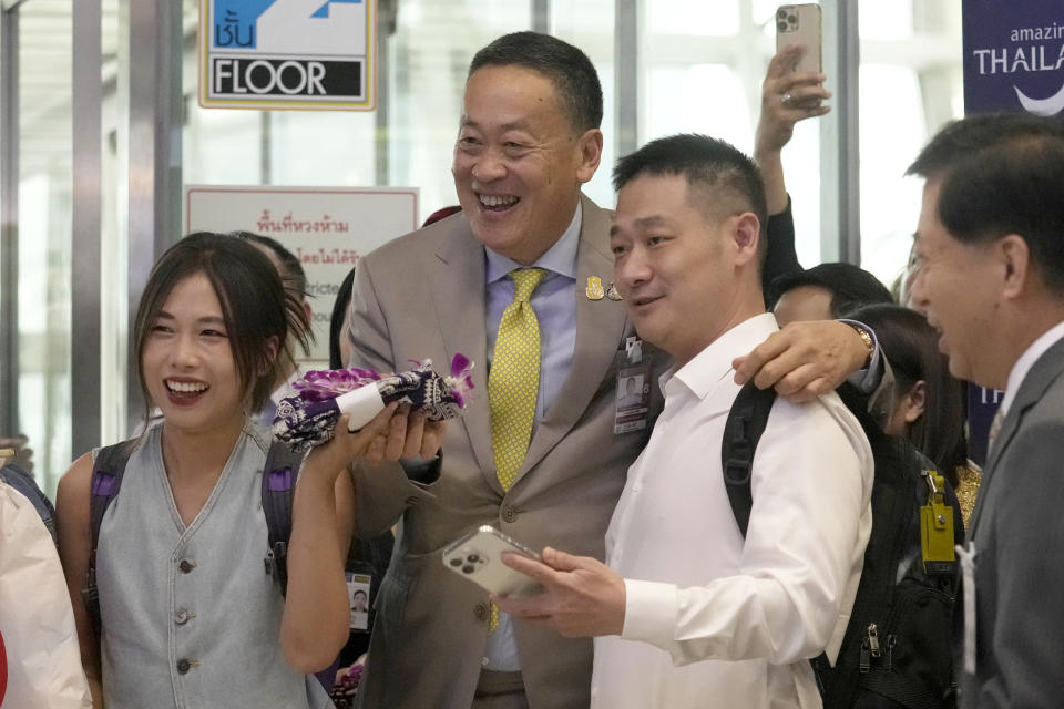 Chinese tourists takes picture with Thailand's Prime Minister Srettha Thavisin, right, on their arrivals at Suvarnabhumi International Airport in Samut Prakarn province, Thailand, Monday, Sept. 25, 2023. Thailand's new government granting temporary visa-free entry to Chinese tourists, signaling that the recovery of the country's tourism industry is a top economic priority. (AP Photo/Sakchai Lalit)