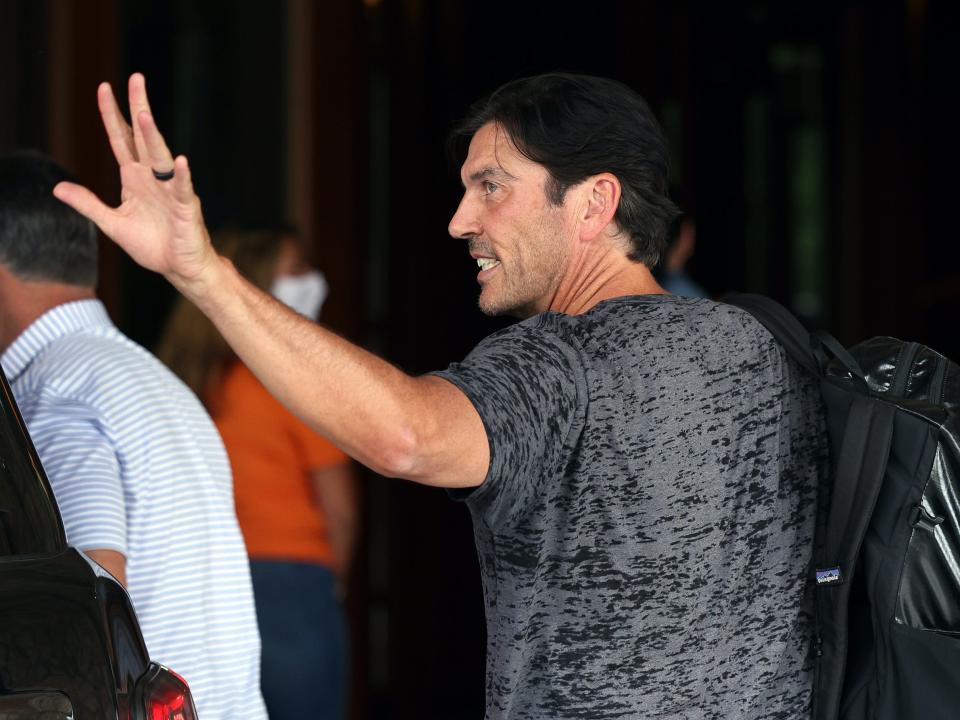 Tim Armstrong waves while looking over shoulder