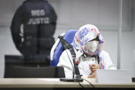 The 96-year-old defendant Irmgard F. sits in an ambulance chair behind a plexiglass screen in a courtroom in Itzehoe, Germany, Tuesday, Oct. 19, 2021. The woman is charged of more than 11,000 counts of accessory to murder. Prosecutors argue that the 96-year-old woman was part of the apparatus that helped the Nazi camp function more than 75 years ago. (Christian Charisius/DPA via AP, Pool)