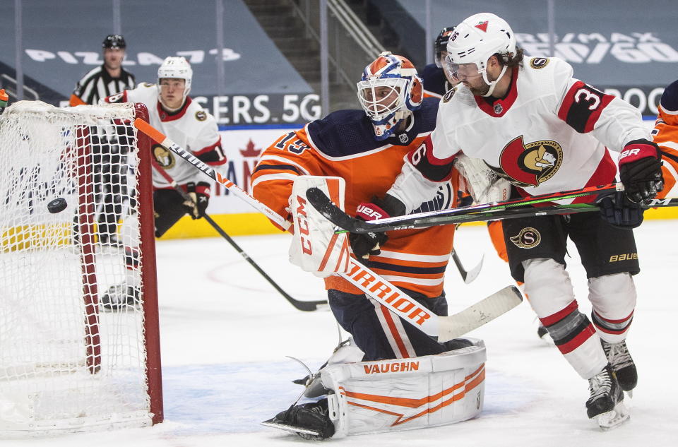 Edmonton Oilers goalie Mikko Koskinen (19) makes a save as Ottawa Senators' Colin White (36) goes for the rebound during third-period NHL hockey game action in Edmonton, Alberta, Monday, March 8, 2021. (Jason Franson/The Canadian Press via AP)