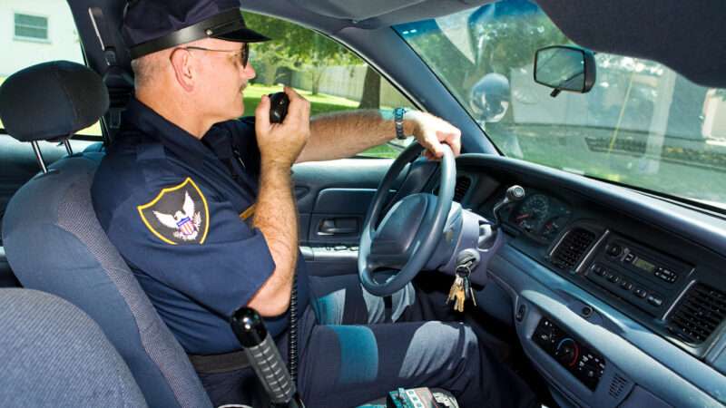 Policeman in his patrol car radioing in.