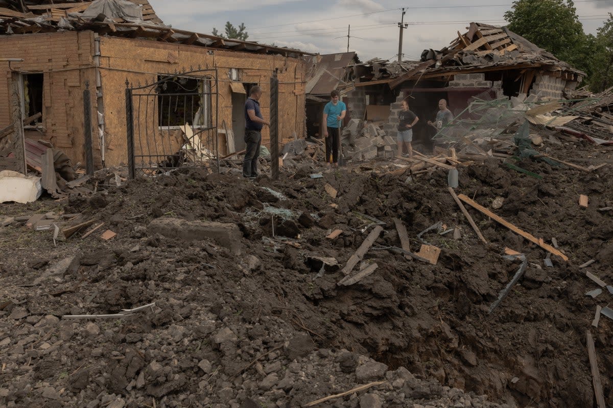 Residents clean debris next to heavily damaged houses following shelling in Pokrovsk, eastern Donetsk region (AFP via Getty Images)