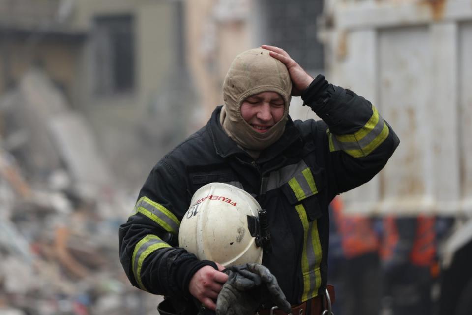 Ein Feuerwehrmann geht weg, während Rettungskräfte die Überreste eines Wohnhauses durchsuchen, das am Samstag in Dnipro von einer russischen Rakete getroffen wurde (Getty)