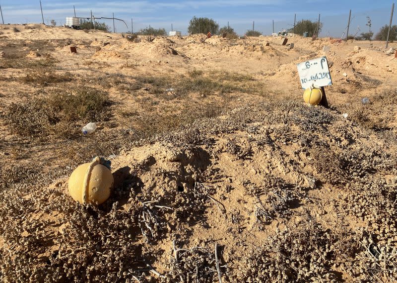 A placard with a date marks a grave in the old cemetery for unidentified migrants outside Zarzis