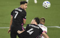 Seattle Sounders midfielder Cristian Roldan, left, heads the ball next to defender Gustav Svensson, center, and Vancouver Whitecaps midfielder Andy Rose during the second half of an MLS soccer match in Portland, Ore., Tuesday, Oct. 27, 2020. (AP Photo/Steve Dykes)