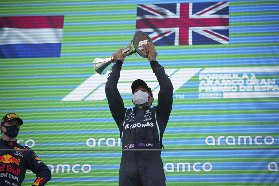 Mercedes driver Lewis Hamilton of Britain lifts his trophy on the podium after winning the Spanish Formula One Grand Prix at the Barcelona Catalunya racetrack in Montmelo, just outside Barcelona, Spain, Sunday, May 9, 2021. At left is second placed Red Bull driver Max Verstappen of the Netherlands. (AP Photo/Emilio Morenatti, Pool)