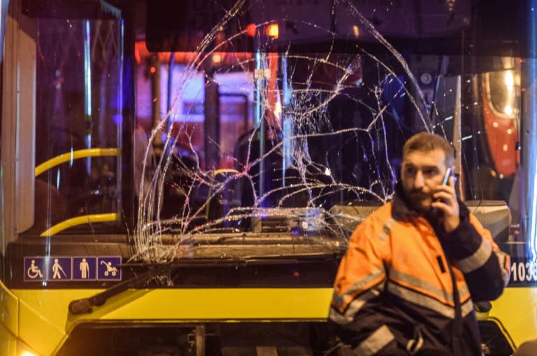 A Turkish emergency worker stands in front of a damaged bus at the site in Istanbul where a car bomb exploded on December 10, 2016