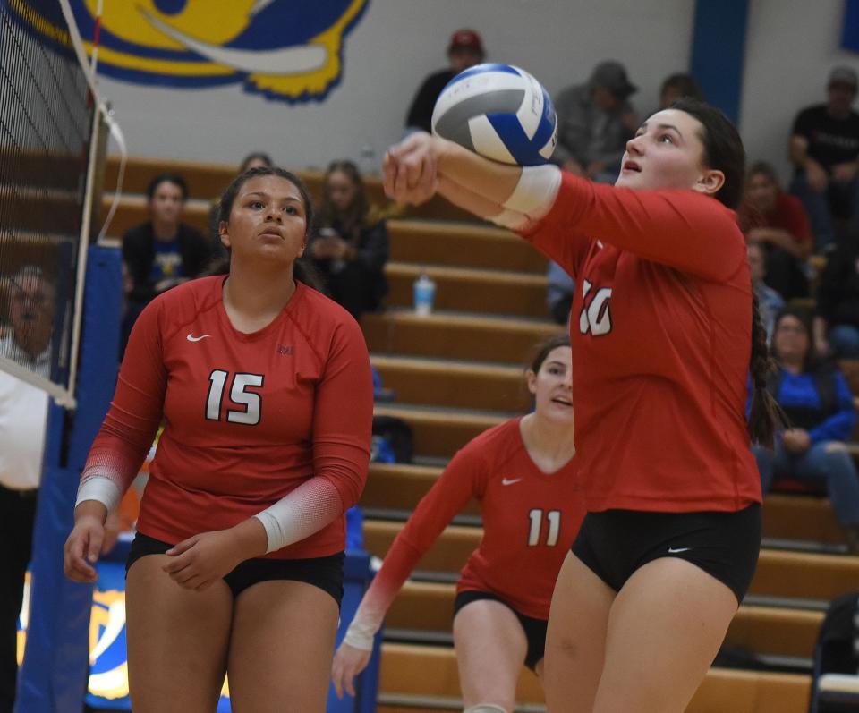 Courtney Nye passes the ball as Milan teammate Mariah Stines watches in the Division 2 District semifinals Thursday.