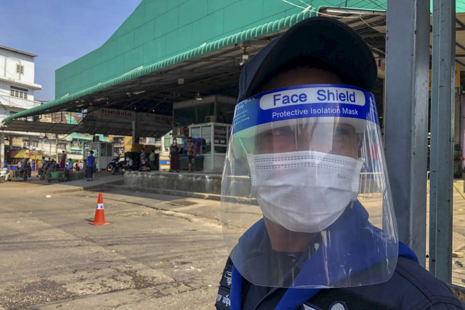 FILE - In this Dec. 20, 2020, file photo, a guard with a face-shield stands near a shrimp market in Samut Sakhon, south of Bangkok. Thailand, which has kept the coronavirus largely in check for most of the year, is facing a challenge from a large outbreak of the virus among migrant workers in the province close to Bangkok.(AP Photo/ Jerry Harmer, File)