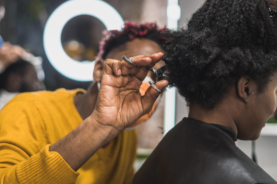 Person cutting another person's hair in the back