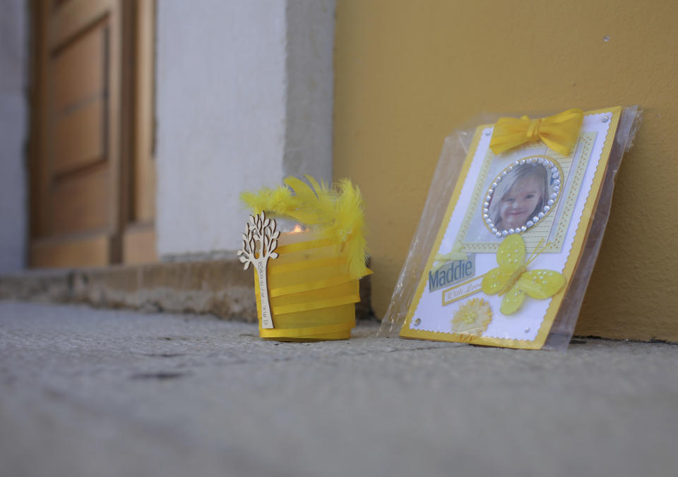 A candle burns next to a photo of missing British girl Madeleine McCann outside the church in the village of Praia da Luz, in southern Portugal, Wednesday, May 3 2017. Madeleine was nearly four year old when she vanished during a family vacation at﻿﻿ ﻿a Praia da Luz resort ten years ago. (AP Photo/Armando Franca)