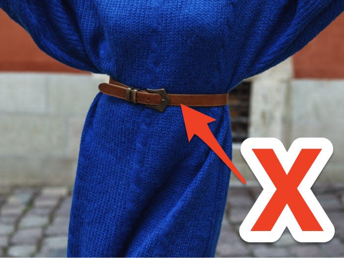 red x and arrow pointing at brown leather belt over a blue sweater dress