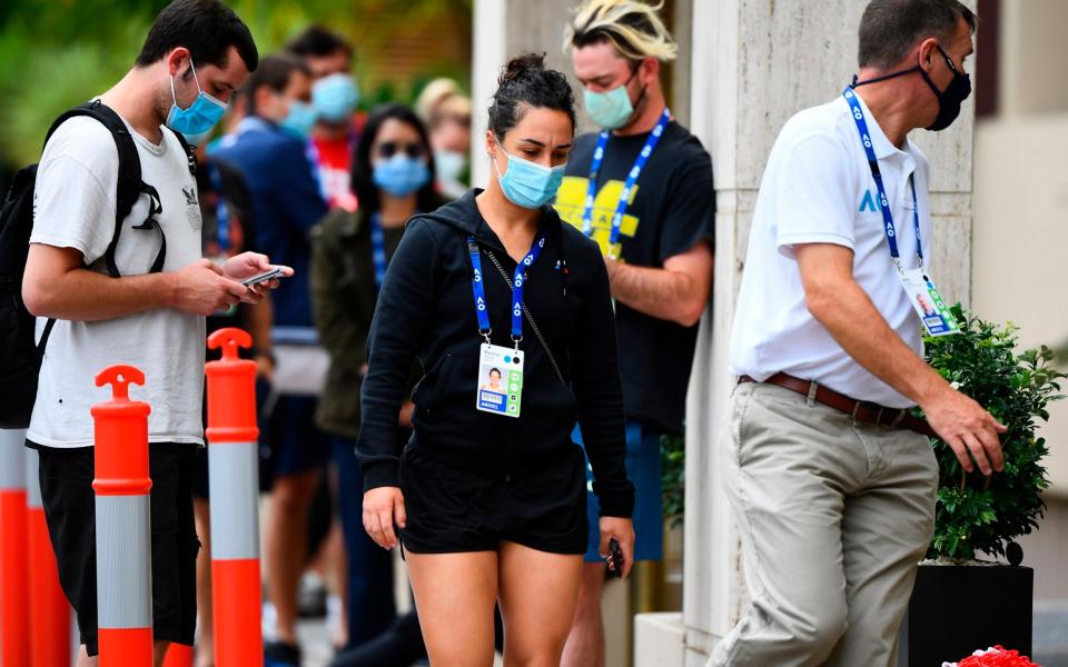 Tennis player Martina Trevisan of Italy (centre) is led into a hotel for a Covid-19 test in Melbourne - AFP