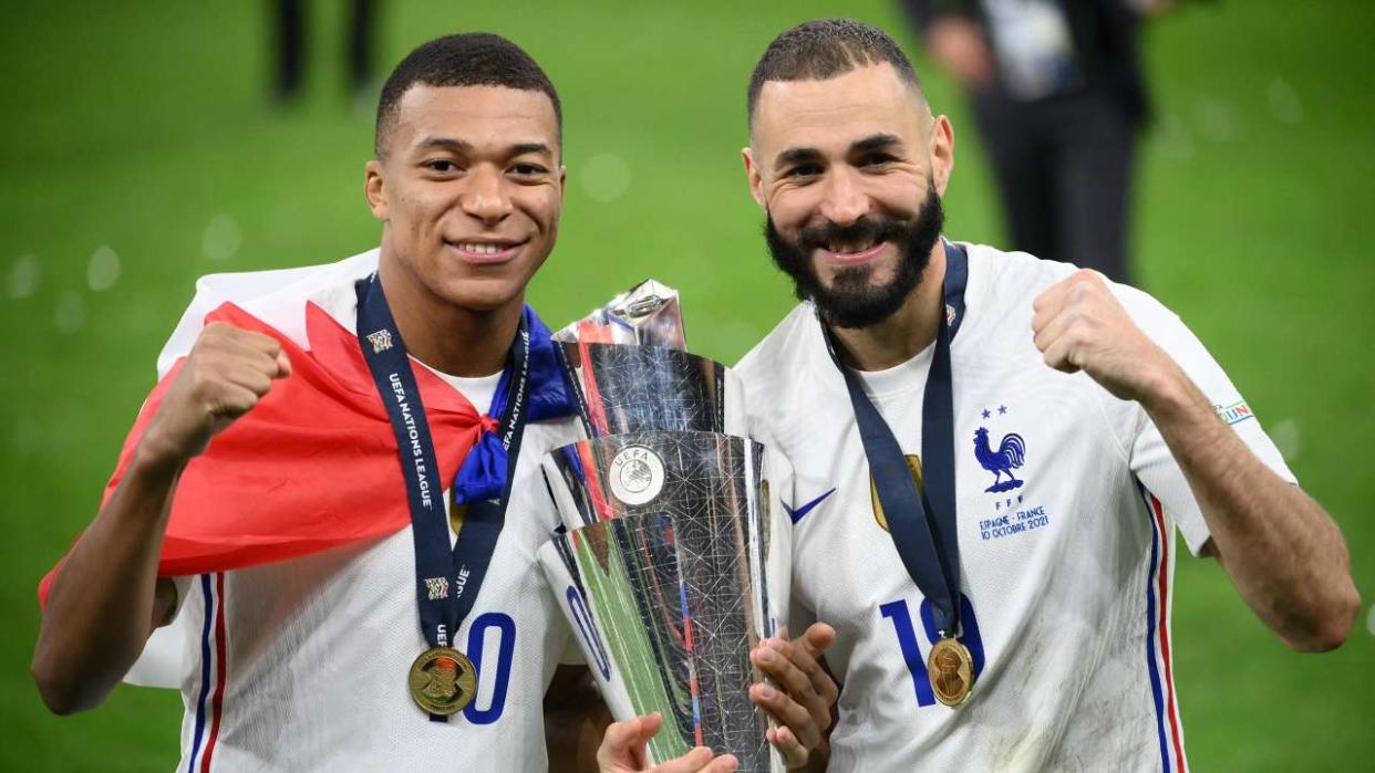 France's forward Kylian Mbappe (L) and France's forward Karim Benzema (R) celebrate with the trophy at the end of the Nations League final football match between Spain and France at San Siro stadium in Milan, on October 10, 2021. (Photo by FRANCK FIFE / AFP)