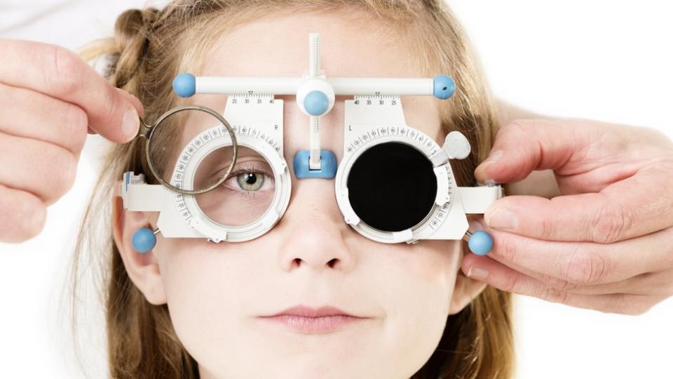 Una niña se hace un examen de ojos.
