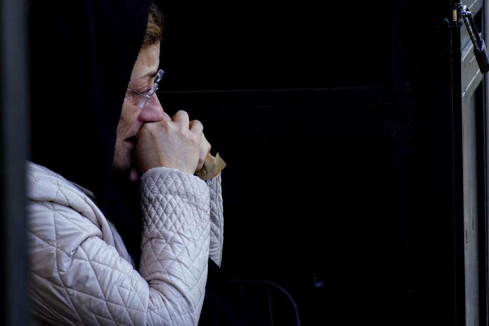 A woman mourns the Turkish Cypriot victims of the earthquake in Turkey, during a funeral procession in the Turkish occupied area in northeast coastal city of Famagusta, Cyprus, on Friday, Feb. 10, 2023. A funeral service was held in Famagusta city for Fahri Arkar, Mert Niyazi Topukcuoglu and brothers Doruk and Alp Akin, who perished in the ruins of their collapsed hotel in the Turkish city of Adiyaman. (AP Photo/Petros Karadjias)