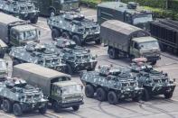 Military vehicles are parked on the grounds of the Shenzhen Bay Sports Center in Shenzhen